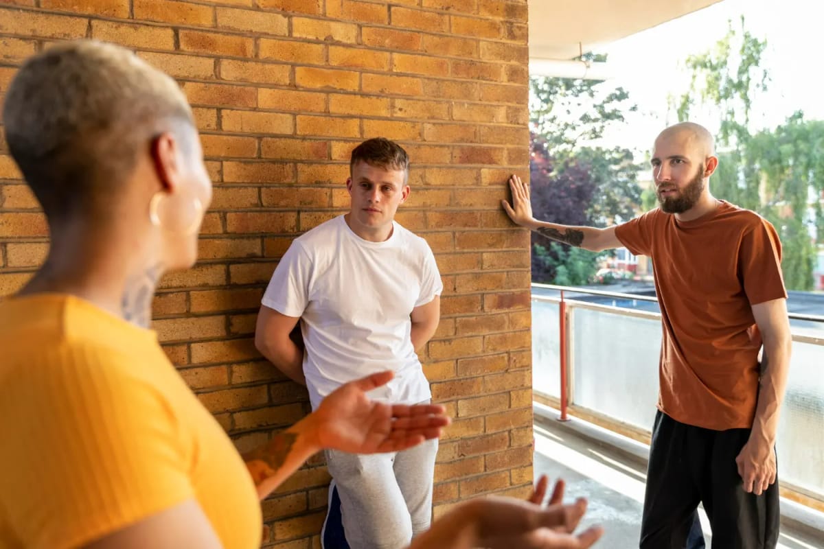 Three people talking together outside, representing peer connection and support in recovery